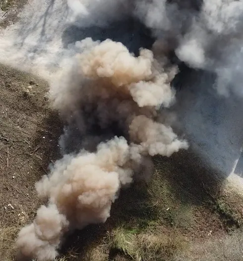 Vue du drone : la poussière soulevée par l’onde retombe sur le champ de tir